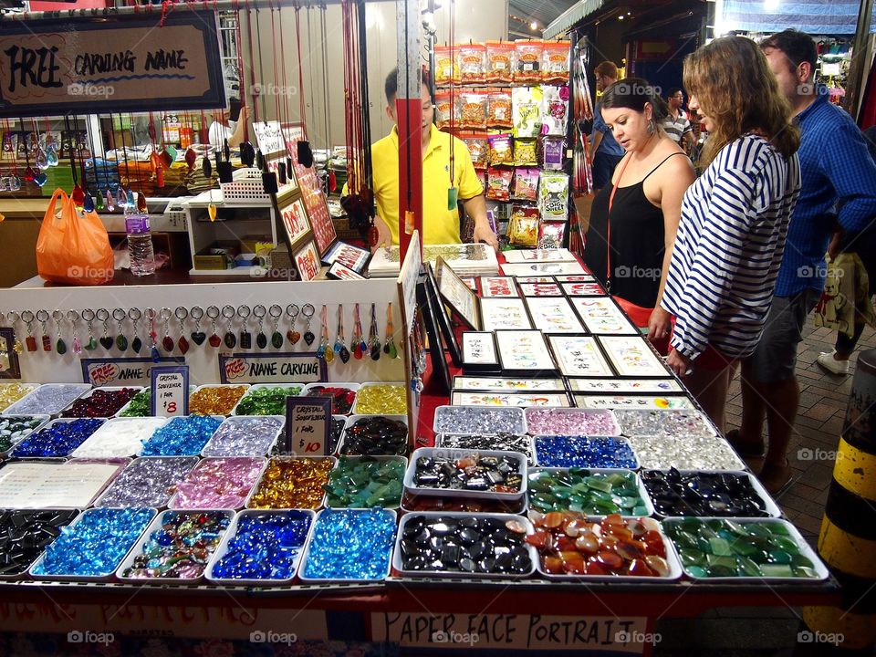 tourists looking at souvenirs sold at chinatown in singapore