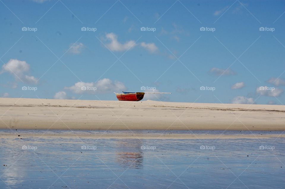 A boat in a desert beach . During this year there was a lot of beach dessert because people couldn’t travel around the world due a pandemic