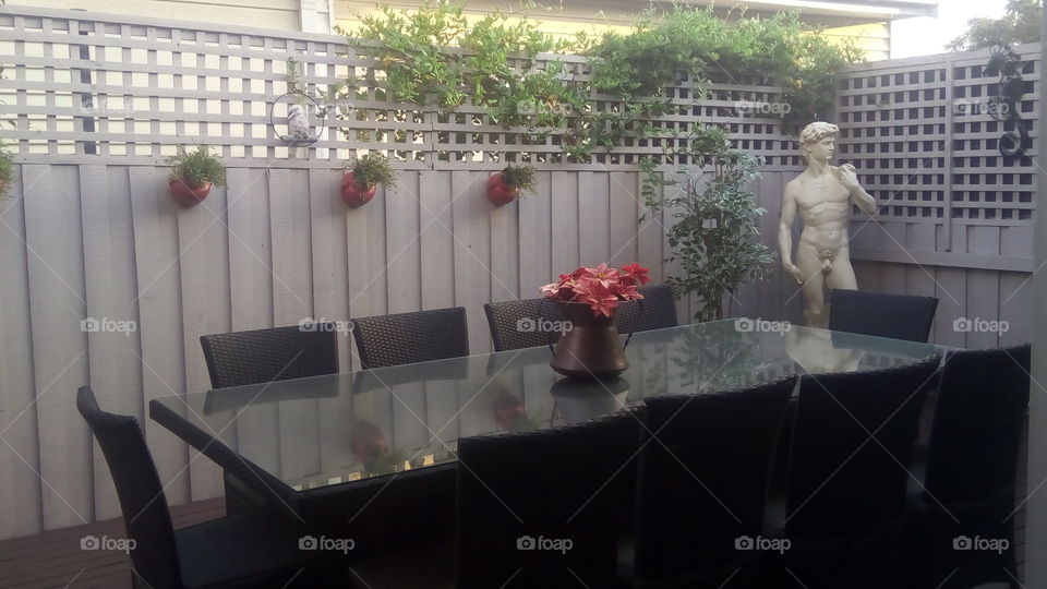 a beautiful outdoor dining area with a classic Italian statue