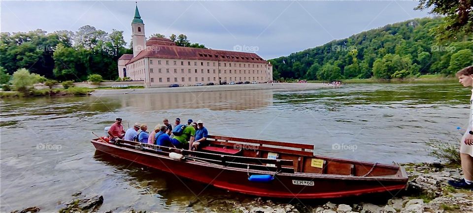 This large old style Bavarian fishing row boat called “Zille” offers tours from “Kelheim” to the “Weltenburg Abbey” and back along the “Danube Gorge”. Across the river we see the pinkish facade of the abbey. 2024. Hypnotic Productions