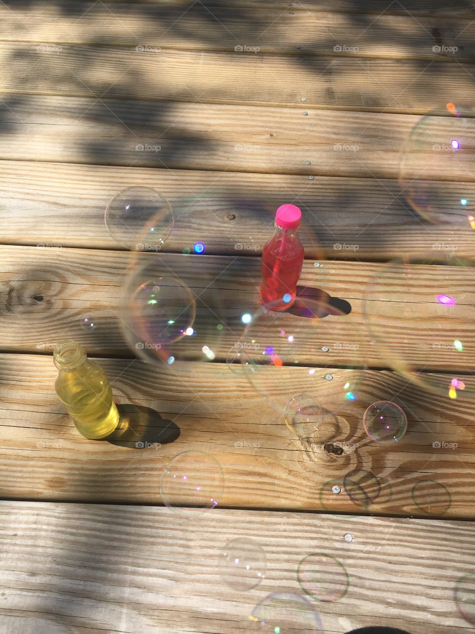 Close up bubbles with soda shaped contianters in background