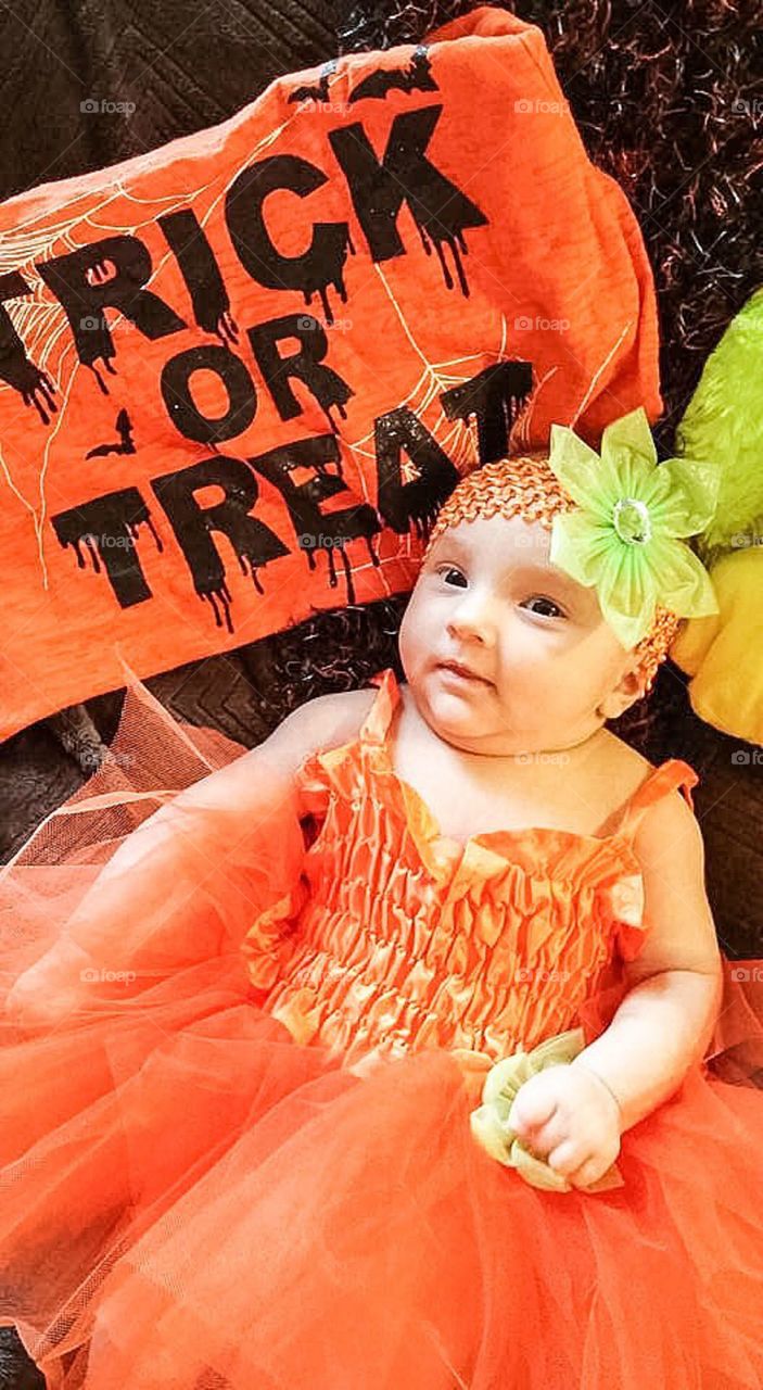 Cute baby girl wearing orange dress