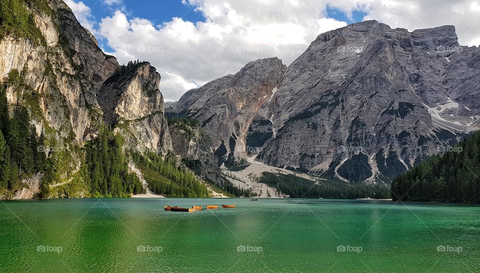Amazing landscape featuring wooden boats on green lake in mountains. Lake Braies in Dolomites in Italy.