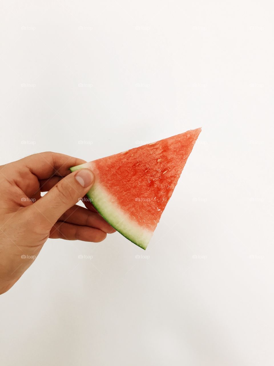 Hand holding watermelon slice