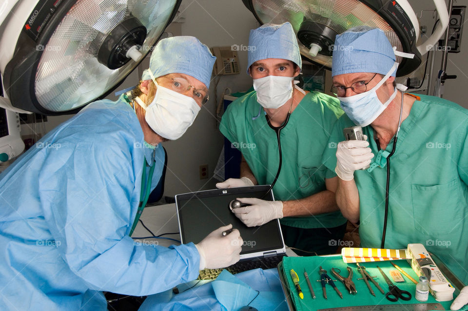 Three men operating on a computer in an emergency room at the hospital