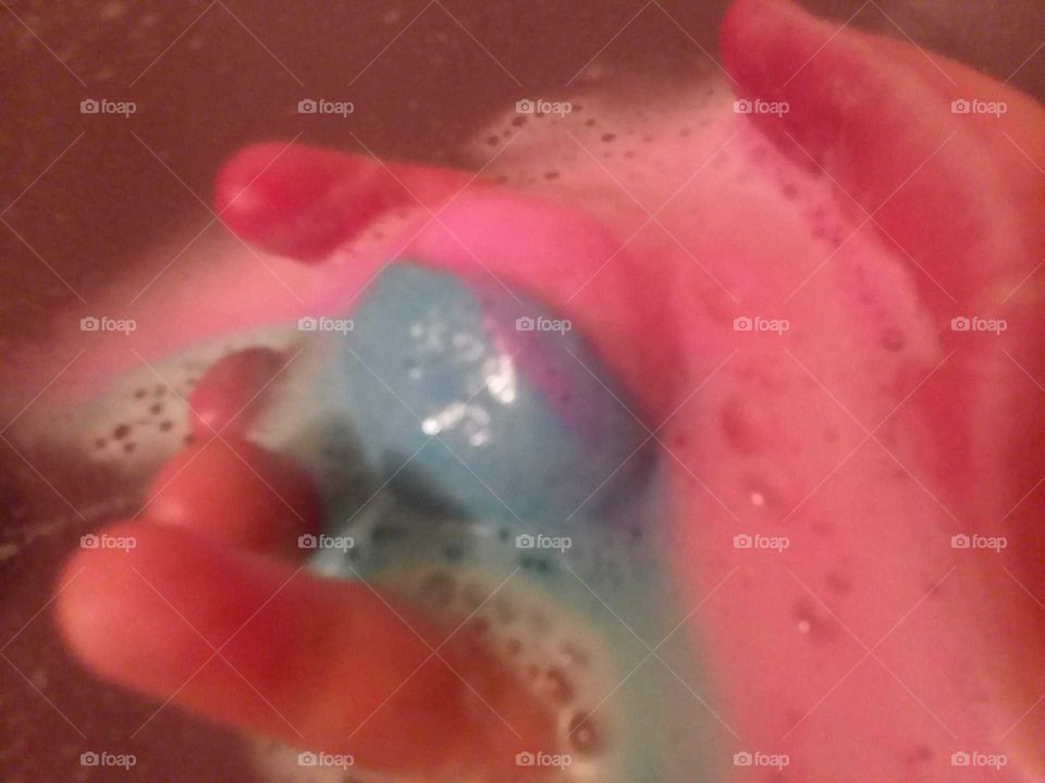 A Pink and Blue Fizzy Bathbomb in the Soapy Water