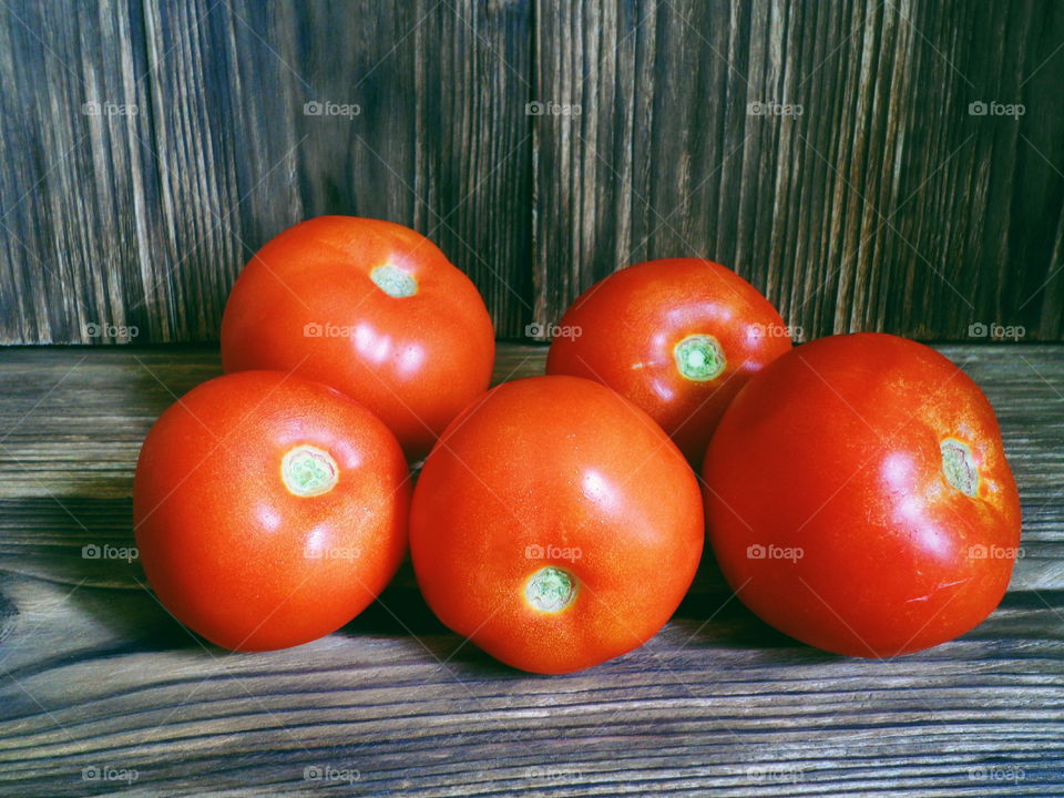 red tomatoes on the burnt boards