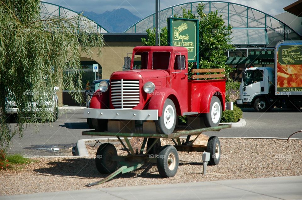 Miniature old farm truck displayed outside of a produce store 