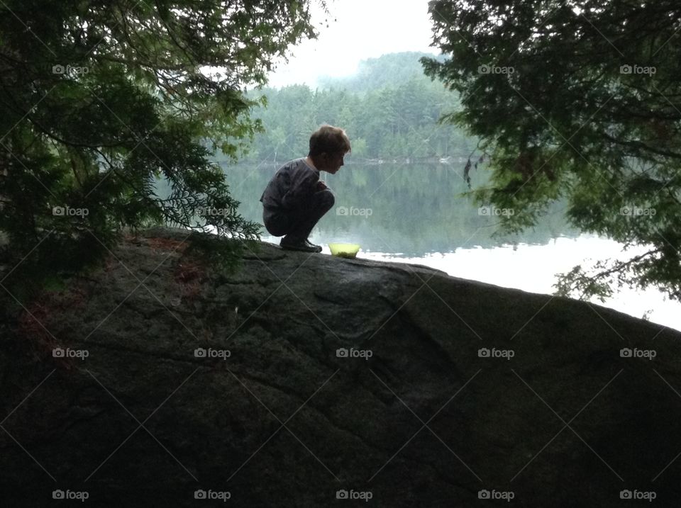 Squirrel boy. Breakfast in pajamas on the rock during a family cannot trip