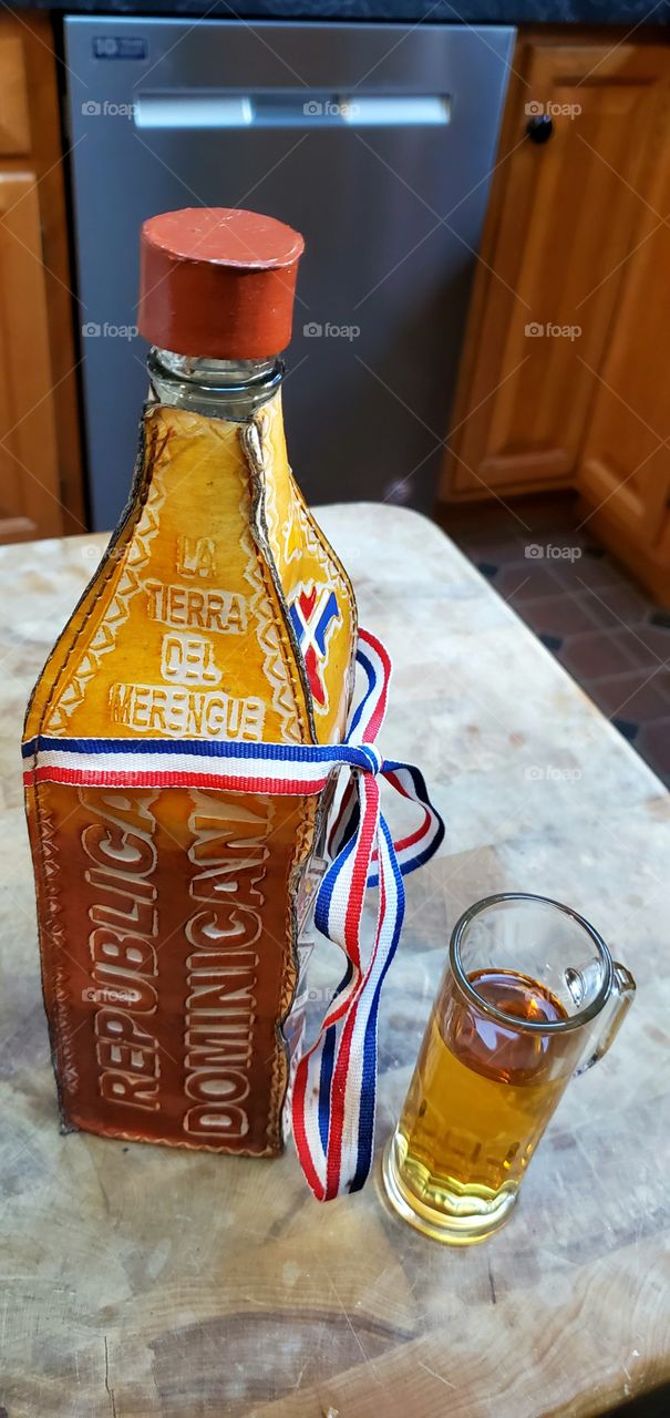 Shot of Mammawanna made in the Dominican Republic. Celebrating with a shot of booze from vacation. Bottle wrapped in etched leather.