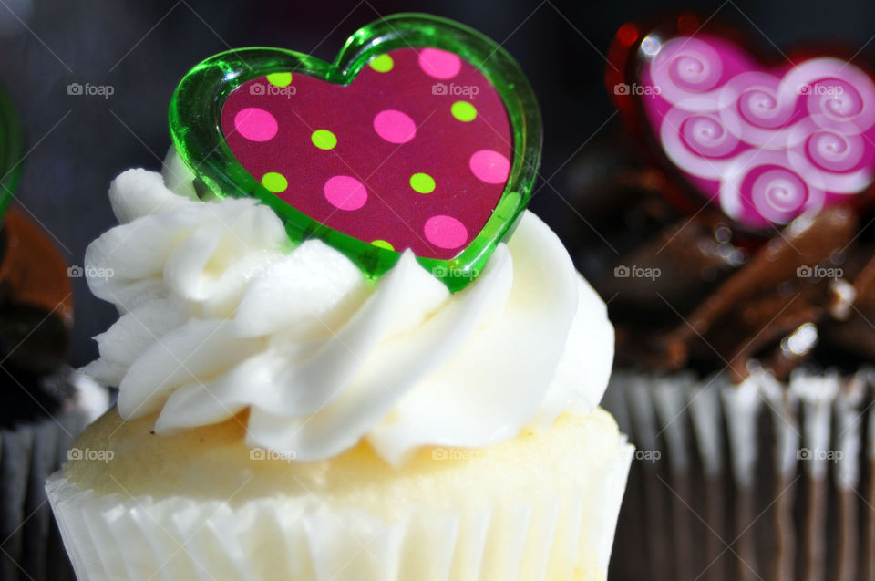 A close-up of a delicious cupcake with a heart on top.