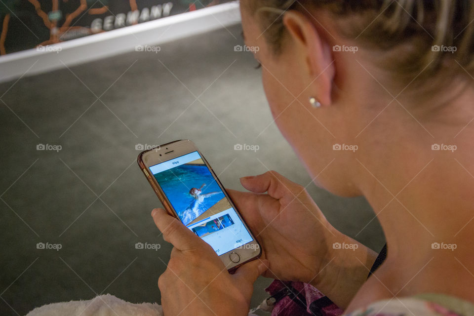 Woman (mom) looking at pictures on her phone.