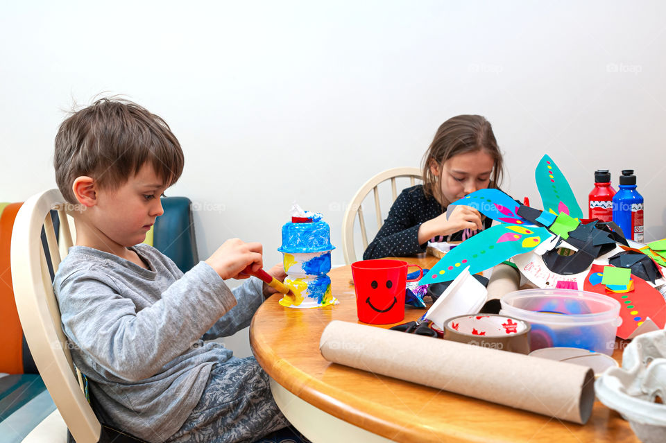 Children use recyclable materials doing arts and crafts at home.