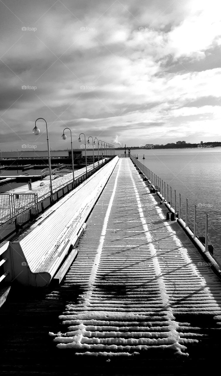 black&white way on the sea, rythm without colour, wooden pier covered with snow, in the sun