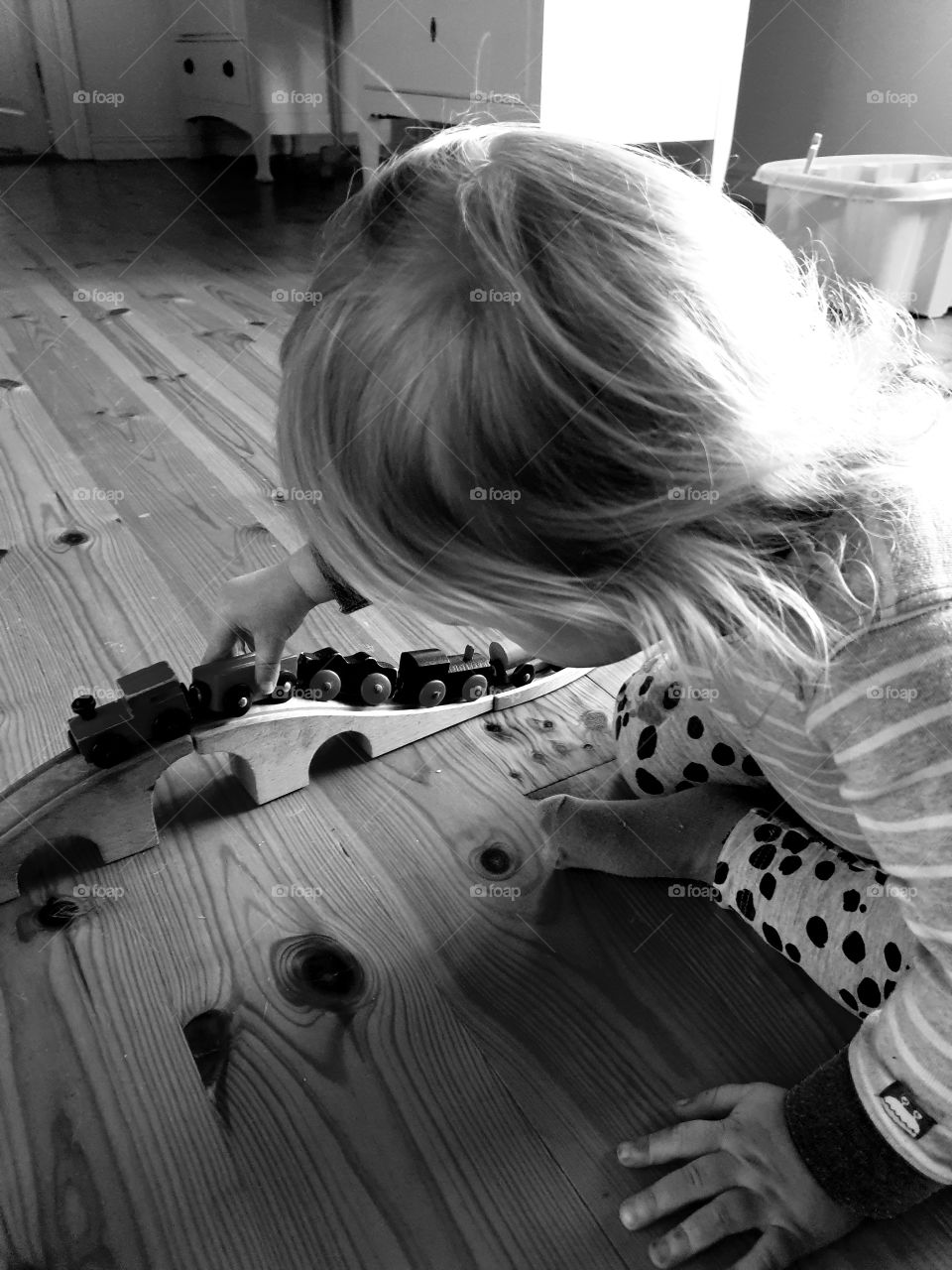 Child playing with traintrack indoors