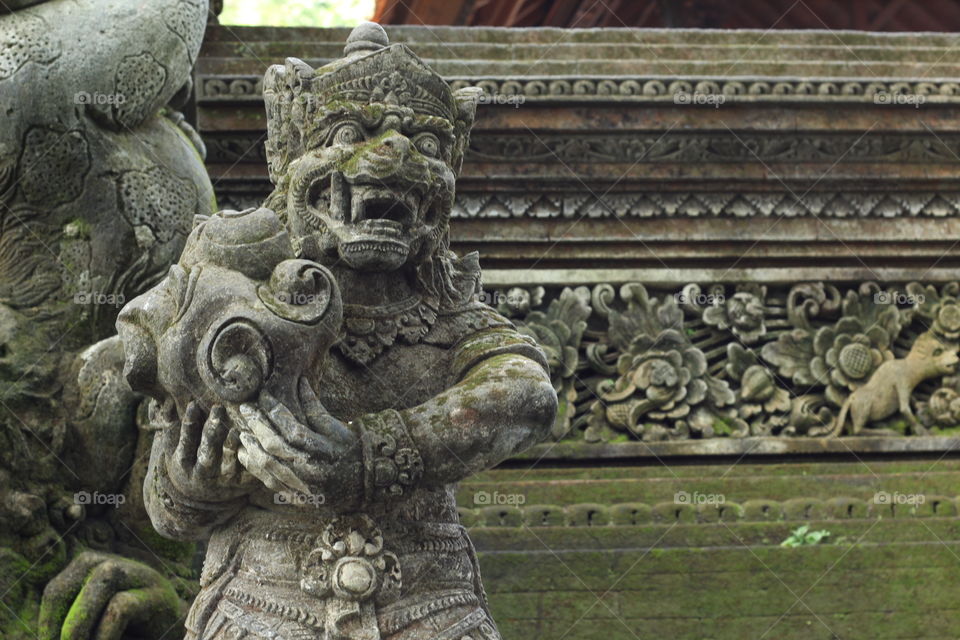 A Hanuman statue in Bali.. A statue hewn from rock stands guard at the steps of a temple in Ubud. 