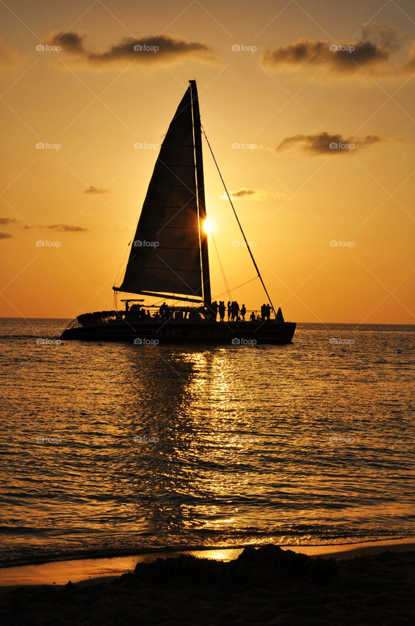 A boat in the sea passing the sunset in Jamaica
