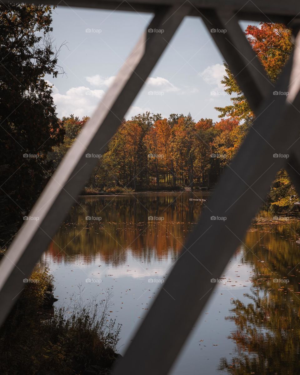 Peering through a metal bridge to see the beautiful fall reflection