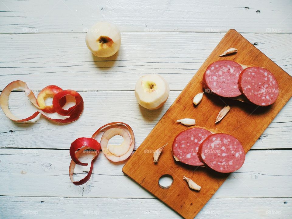 sandwiches with sausage, garlic, peeled apple on a cutting board