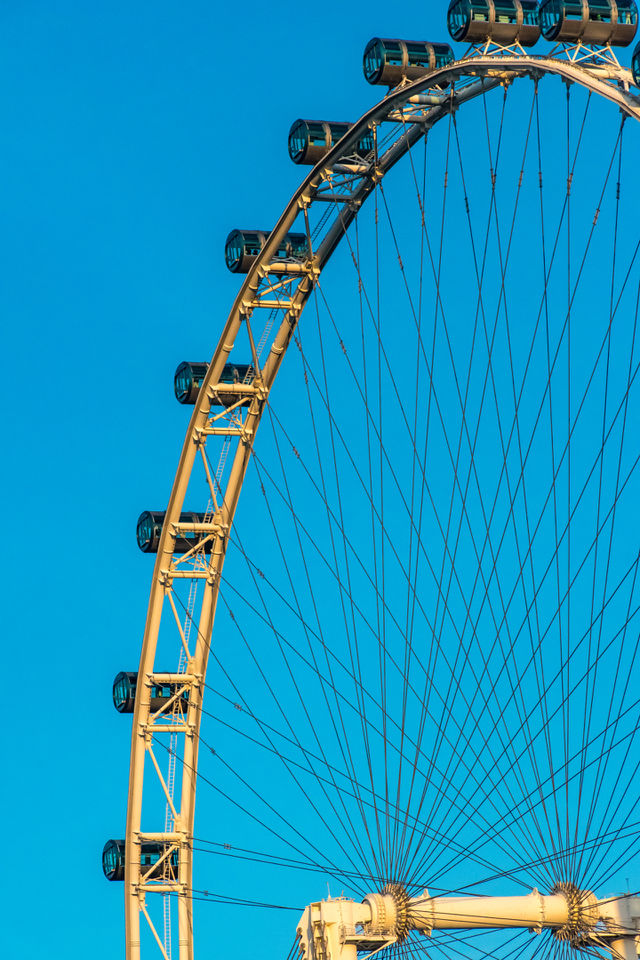 The ferris wheel touched the bright blue sky