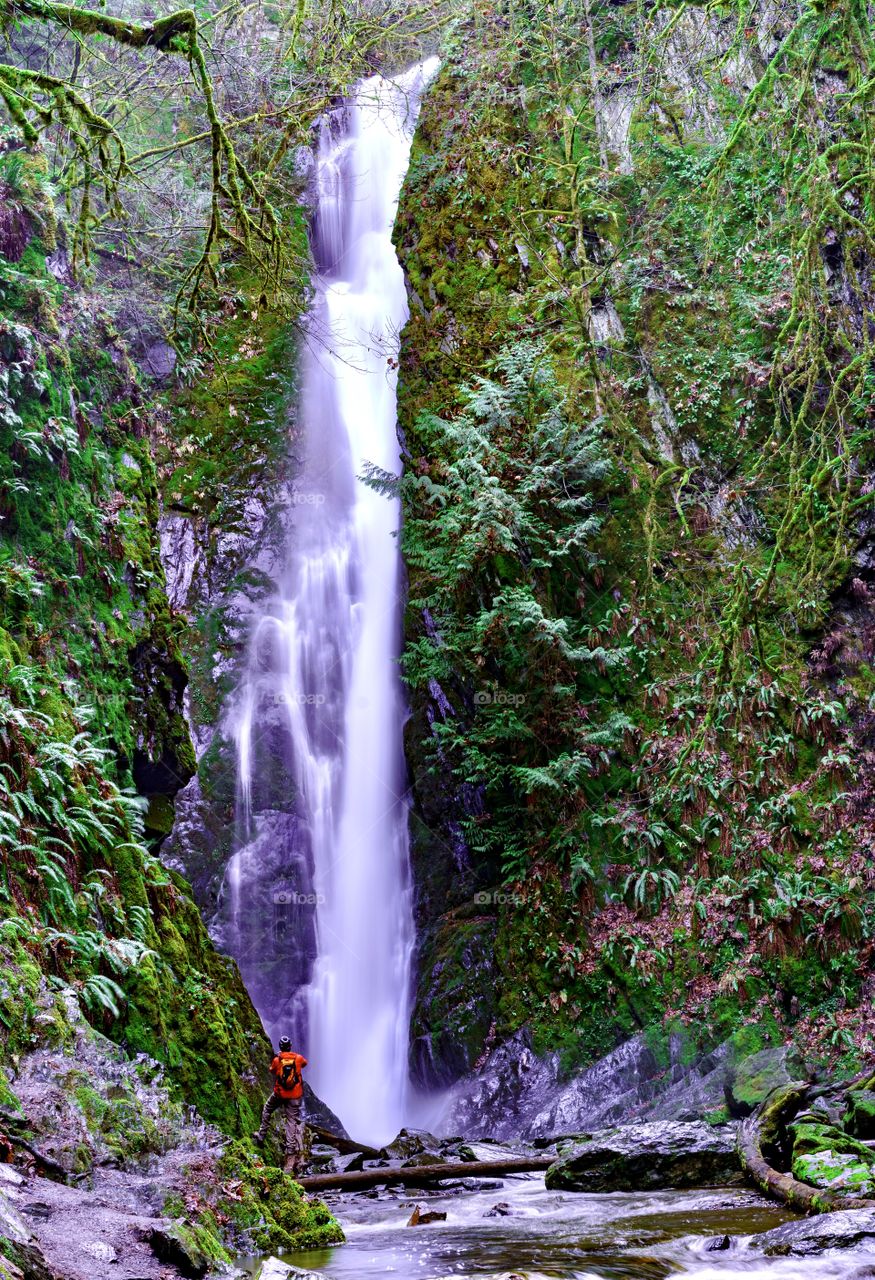 Man taking photo of the Goldstream Park Waterfall on Vancouver Island, Canada 