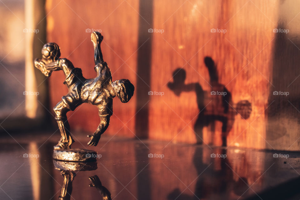 Macro photography of a little sculpture of a football player that represents childhood dreams