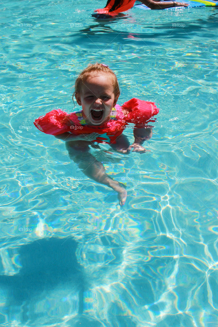 A young girl swimming in pool