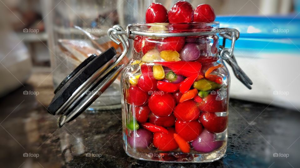 Pimentas frescas em frasco de vidro.