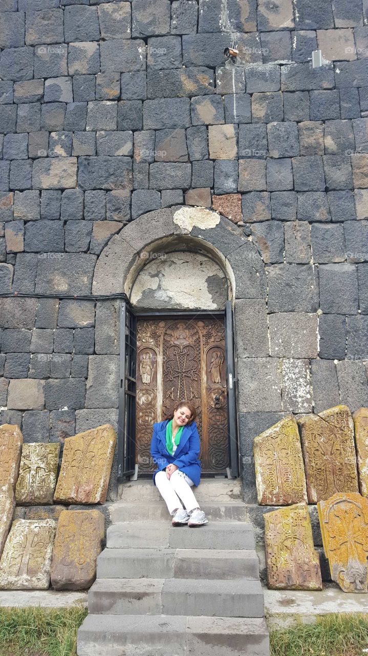 Woman sitting near old door