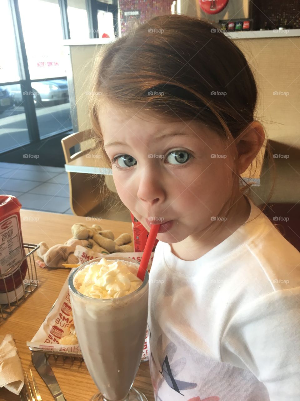 Beautiful little girl with milkshake