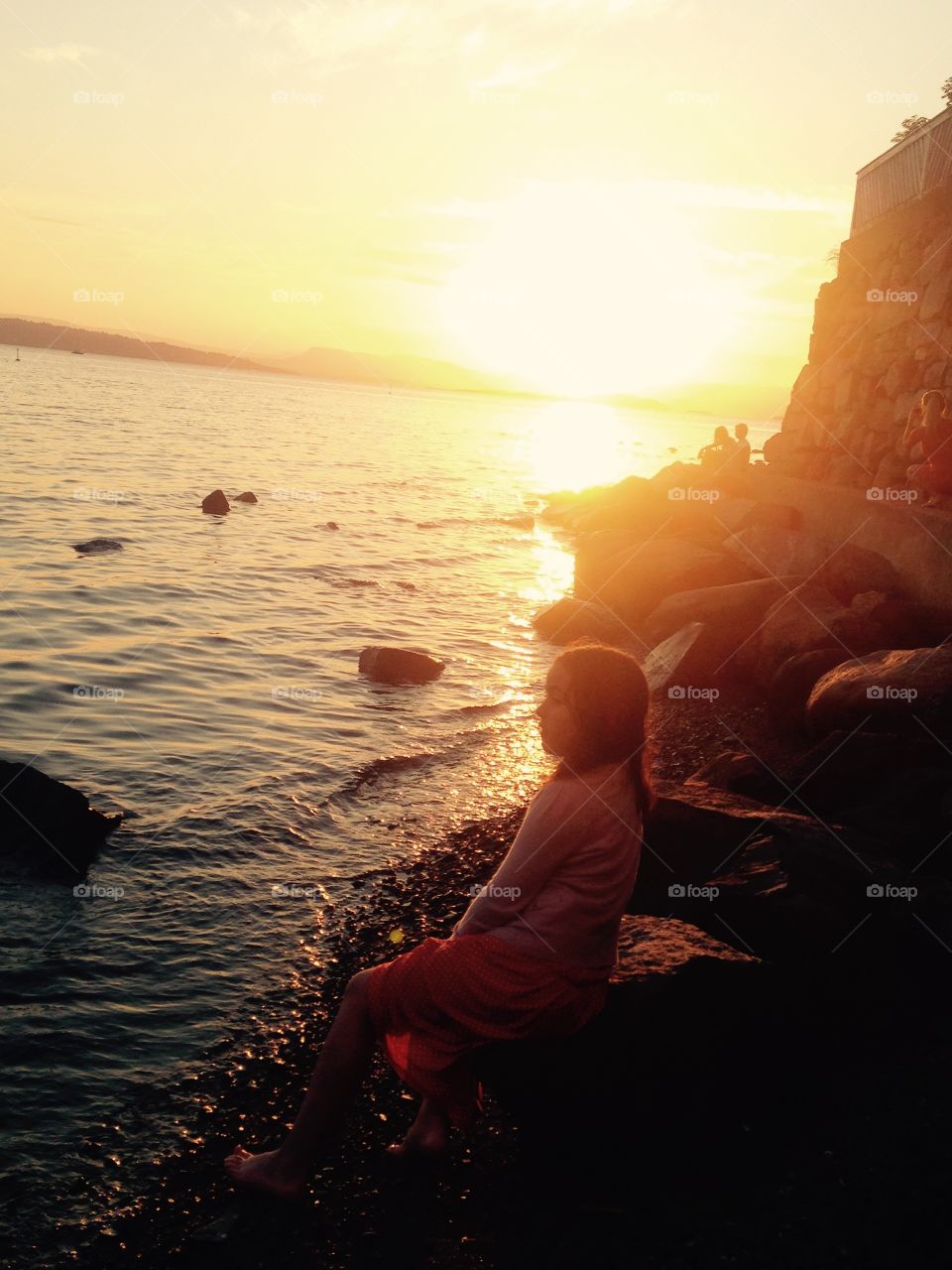 The girl and The sun. The girl sat and watch the sunset after Long swimming day with friends at fiskevollen in Oslo, Norway. 