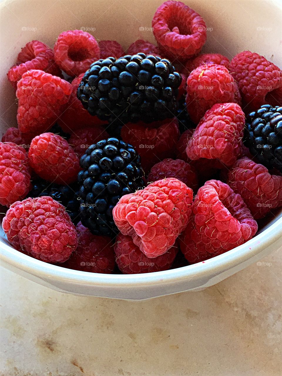 Raspberries and blackberries in bowl