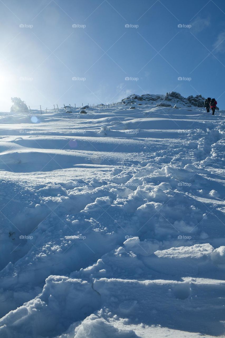 Two climbers at background climbing towards the summit