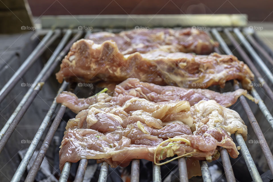 Pork and beef roast on the grill made of stainless tanks in park.