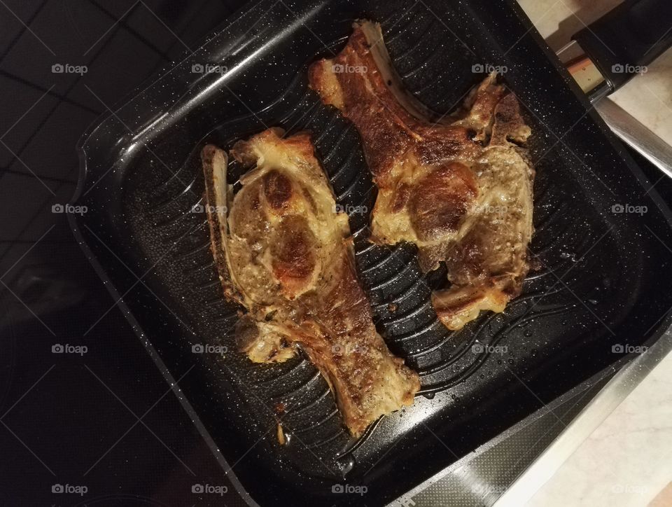 two pork chops in frying pan