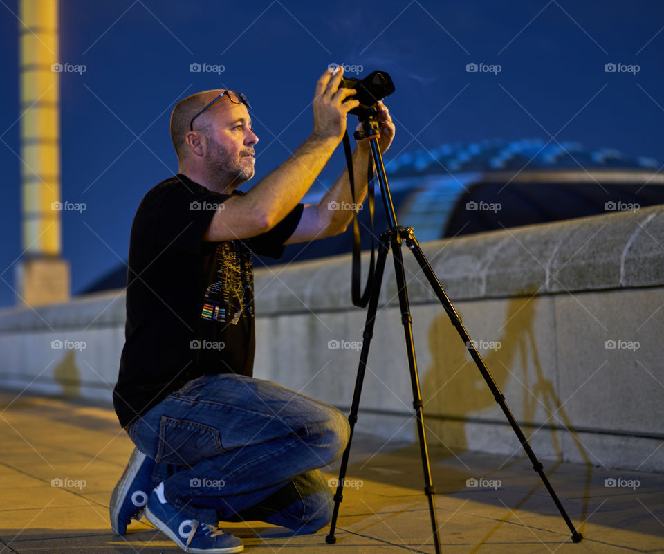 Young photographer with camera on tripod