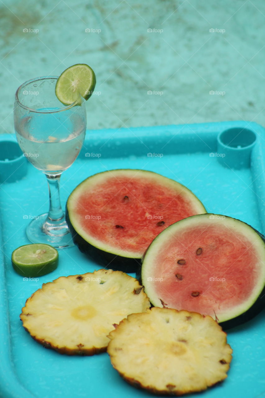 Summer special photography with fruits #summer special photography #Importance of adding water rich fruits in your diet during summers #watermelon, pineapple and lemon juice in blue colour background