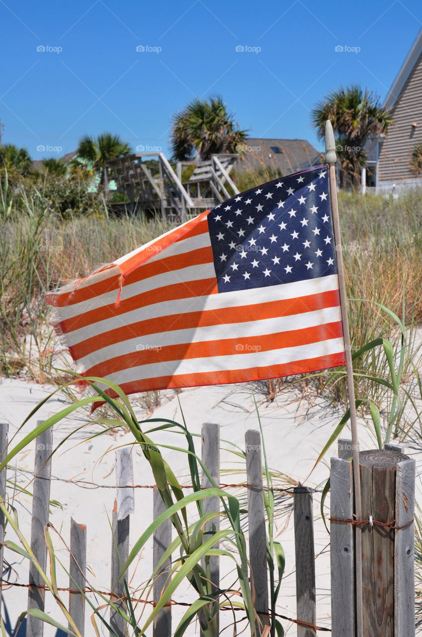 American Flag blows in the wind at the beach.