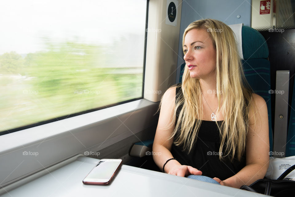 Woman looking out the window on the train from Gatwick Airport to London.