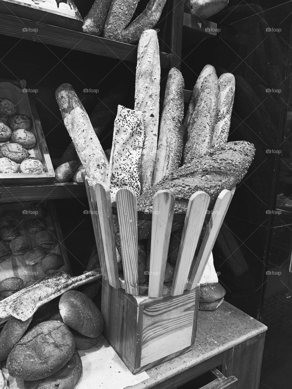 Bunch of breads in a wooden basket in a bakery store in black and white 