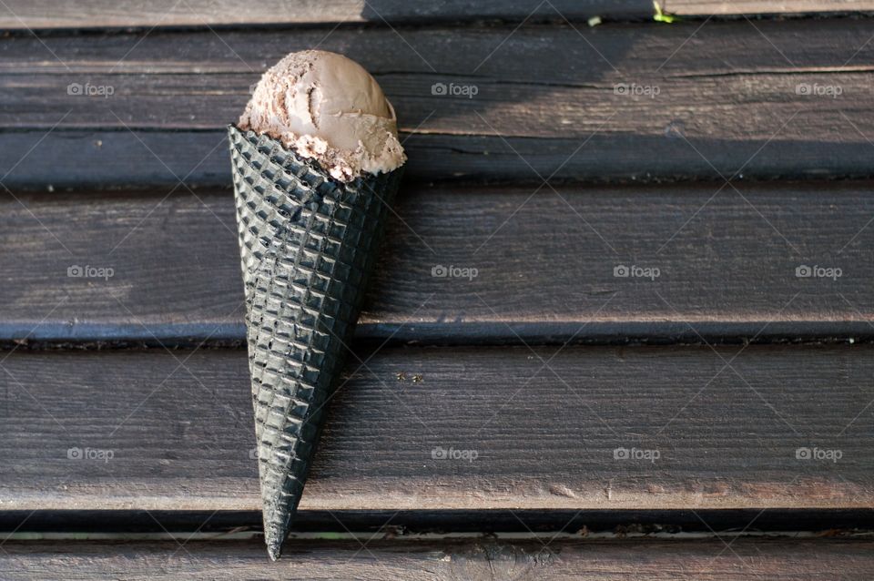 Chocolate ice cream on brown bench