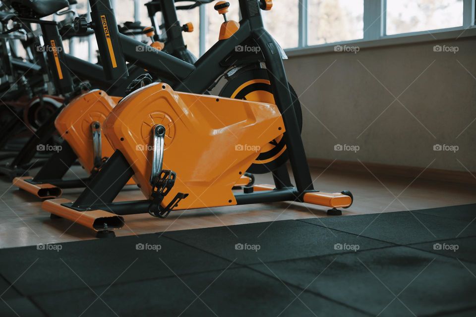 Fitness club with an orange  training exercise bikes . close up .