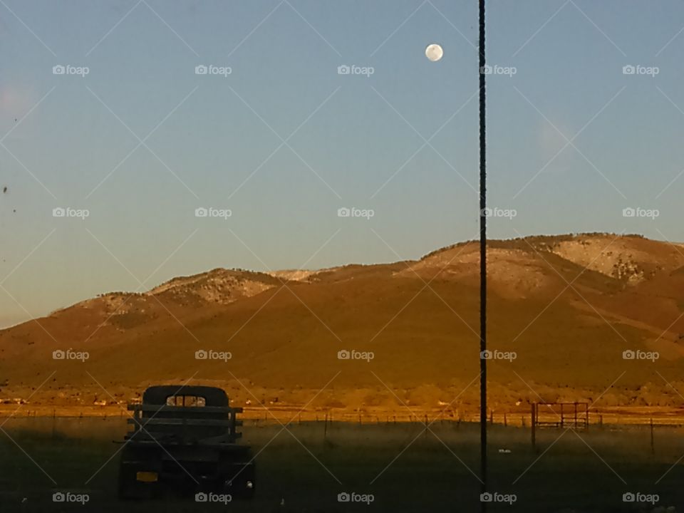 old truck parked viewing sunset over mountains