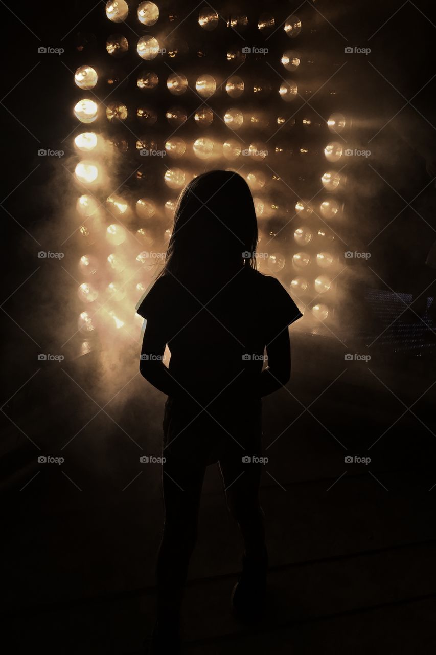 Silhouette of a girl in front of lights 