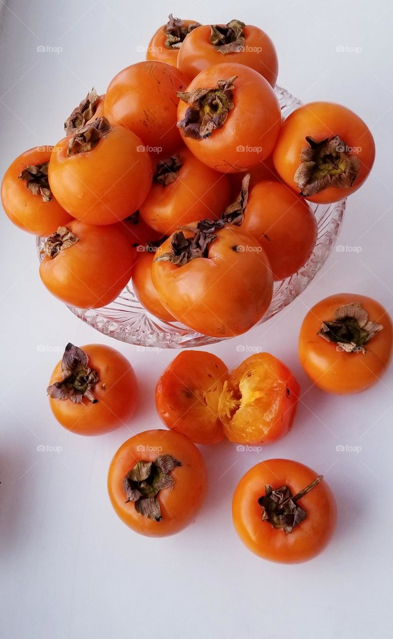 Orange sweet ripe December persimmon fruits in a vase