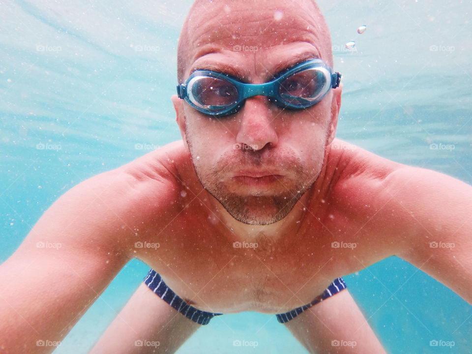 man with goggles. man holding breath underwater wearing goggles