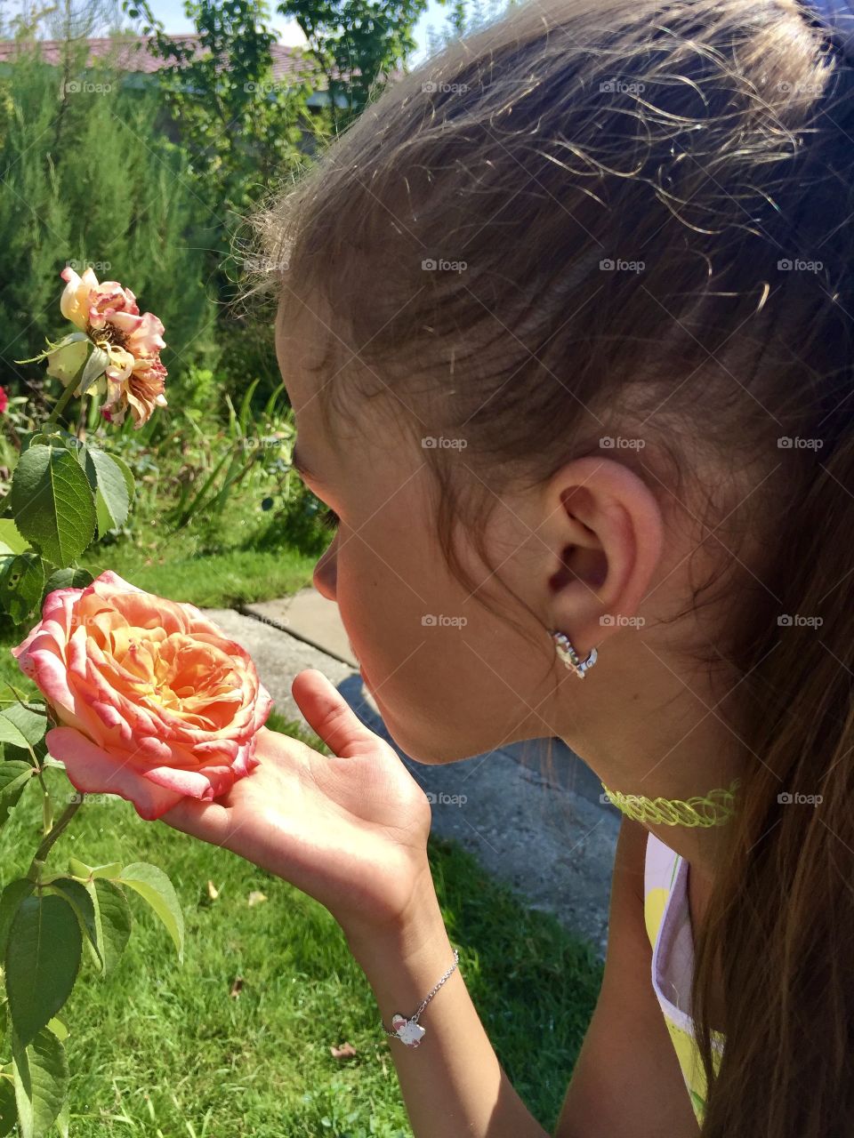 Girl sniffing a rose