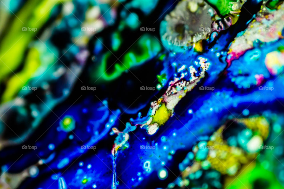 The ink to refill the printer cartridge was spilled onto the white washbasin and the paints blended into abstract drips and patterns.