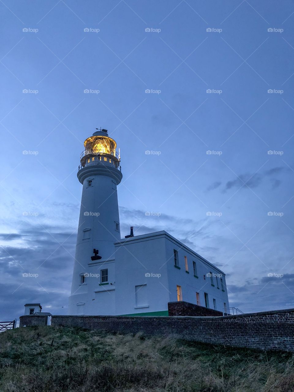 A blue hour shot of Flamborough head lighthouse with a low angle point of view. Flamborough, UK.