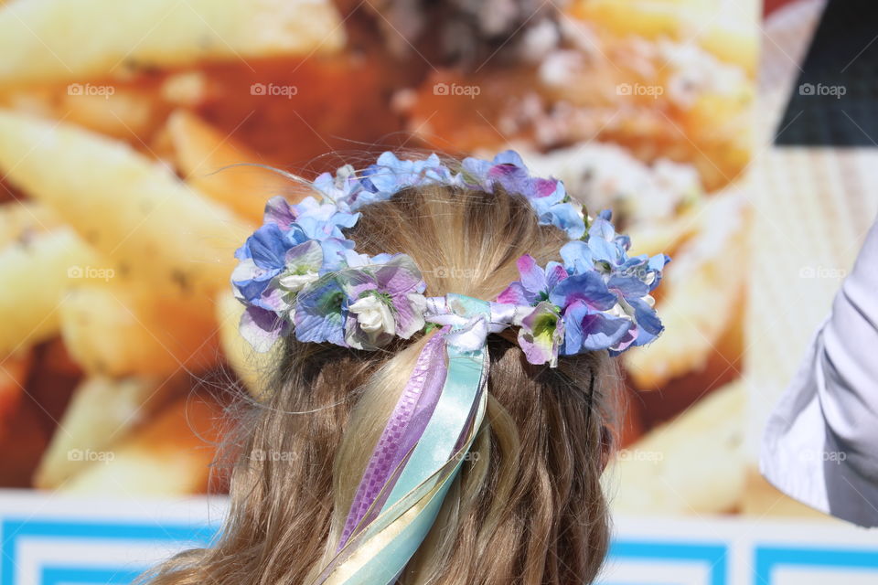 Flower crown in hair of young blond girl outdoors festival 